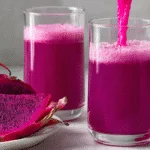 Bright purple smoothie in a clear glass with sliced dragon fruit