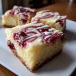 Close-up of a slice of Cranberry Bliss Bars, featuring a white drizzle and swirls of cranberry.