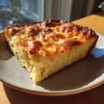 A golden-brown slice of Eggnog French Toast Bake on a plate, with a fluffy interior.