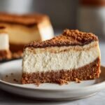 A delicious slice of Gingerbread Cheesecake with a graham cracker crust and creamy filling.