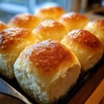 Close-up of golden brown, fluffy dinner rolls in a baking pan, ready to be served.