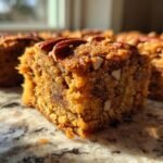 Close-up of a bite-sized Maple Pecan Blondie, showing chunks of pecans and a chewy texture.