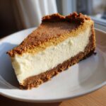 A perfect slice of Pumpkin Cheesecake with a creamy white filling and a rich crust.