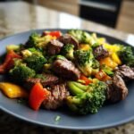 A plate of delicious Keto Steak and Veggies, featuring tender steak bites, broccoli florets, and colorful bell peppers.