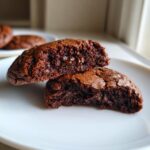 A halved Chocolate Brownie Cookie showing the gooey center. Perfect for a tasty treat!