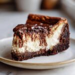 A slice of Chocolate Cottage Cheese Cheesecake with a rich chocolate topping on a plate.