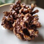 Close-up of homemade Christmas Chocolate Pinecones drizzled with melted chocolate on a white plate.