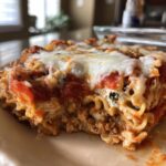 A slice of Easy Cottage Cheese Veggie Pasta Bake with melted cheese, tomato sauce, and pasta layers.