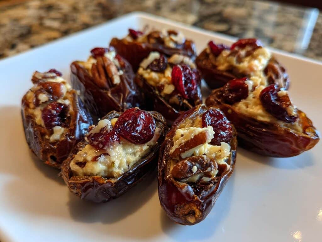 Close-up of Cranberry Pecan Cream Cheese Stuffed Dates on a white plate.