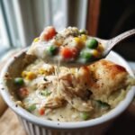 Spoonful of creamy Crustless Chicken Pot Pie with chicken, peas, carrots, and corn.