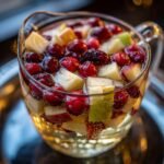 Pitcher of Festive White Christmas Sangria with cranberries, apples, and pears.