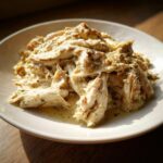 Close-up of Garlic Parmesan Crockpot Chicken served on a white plate, showcasing its creamy sauce and tender texture.