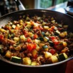 A skillet filled with Ground Turkey and Zucchini Skillet, tomatoes, and herbs, ready to serve.