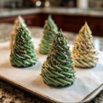 Close-up of colorful meringue trees decorated with sprinkles, ready for the holidays. Perfect Meringue Trees recipe.