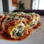 Delicious Mushroom and Spinach Lasagna Rolls topped with tomato sauce, cheese, and parsley.