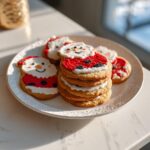 Festive Puppy Santa Butter Cookies decorated with red and white icing, stacked on a white plate.