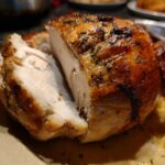 Close-up of sliced Roasted Butterball Turkey Breast with golden-brown skin and herbs.