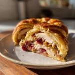 A slice of savory Turkey and Cranberry Crescent Ring with flaky crust, turkey, and cranberry filling.