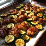 Sheet pan with hot honey garlic chicken and zucchini, glazed and ready to serve.