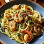 A plate of Asparagus Shrimp Angel Hair Pasta, garnished with herbs and spices, ready to be served.