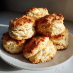 A stack of golden brown Breakfast Protein Biscuits on a plate, ready to eat.
