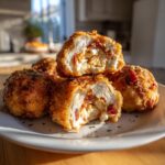 Delicious Buffalo Chicken Bacon Mozzarella Bombs cut open to show the filling on a white plate.