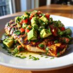 Grilled Cilantro Lime Chicken with Avocado Salsa on a white plate, garnished with fresh cilantro.