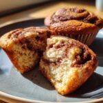 Close-up of Cinnamon Roll Protein Muffins, one muffin broken open to show the inside texture.