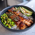 A vibrant Crispy Salmon Bowl filled with rice, edamame, avocado, and perfectly cooked salmon.