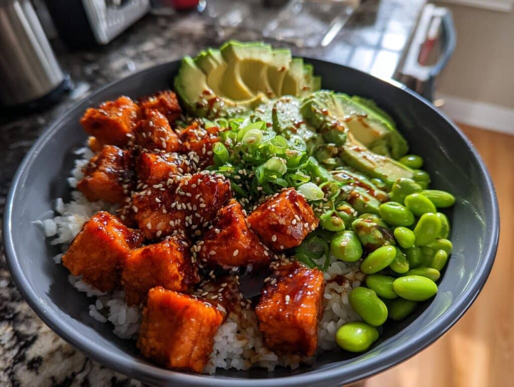 A vibrant Crispy Salmon Bowl with rice, glazed salmon, avocado, edamame, and green onions.