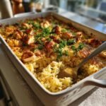 A delicious Garlic Butter Chicken and Rice Casserole in a white baking dish, garnished with parsley.