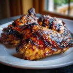 Close-up of juicy Grilled Honey Mustard Chicken pieces on a white plate, showcasing the glaze and grill marks.