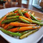 Close-up of Honey Glazed Carrots and Green Beans on a white plate, ready to serve.