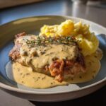 Close-up of Irish Chicken in Whiskey Cream Sauce served with mashed potatoes and garnished with thyme.