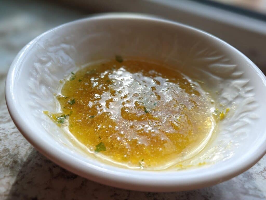 Close-up of freshly made Lemon Caper Sauce in a small white bowl, ready to serve.