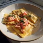 A plate of Lobster Ravioli with Lemon Butter Sauce, garnished with fresh chives.