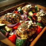 Baked Mediterranean Chicken Zucchini Bake with feta, zucchini, red pepper, and red onion in a wooden pan.