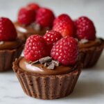 Close-up of No Bake Raspberry Chocolate Mousse Cups with fresh raspberries and chocolate shavings.