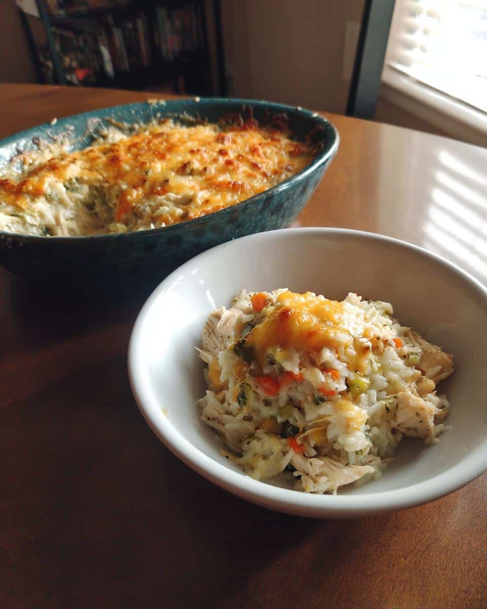 Disgustingly Easy Pioneer Woman Chicken Rice Casserole 6 A bowl of Pioneer Woman Chicken Rice Casserole with a baking dish in the background.