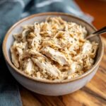 A bowl of creamy Ranch Chicken Crock Pot recipe, seasoned with herbs and ready to serve.