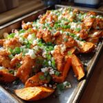 Savory Sheet Pan Buffalo Chicken Sweet Potato with green onions and cheese on a baking sheet.