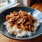 A bowl of Slow Cooker Honey Garlic Chicken served over white rice, ready to eat.