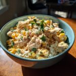 A bowl of Slow Cooker Street Corn Chicken, featuring chicken, corn, cheese, and herbs.