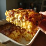 A slice of cheesy spaghetti squash au gratin, showcasing the golden-brown crust and creamy filling.