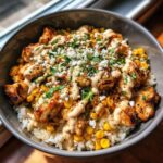 A delicious Street Corn Chicken Rice Bowl with grilled chicken, corn, rice, cheese, and a creamy sauce.