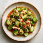 Overhead shot of Asian Cucumber Salad with Crab, featuring cucumbers, crab meat, chili, and herbs in a light sauce.