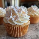 Close-up of Baby In Bloom Cupcakes decorated with buttercream frosting and delicate sugar flowers.