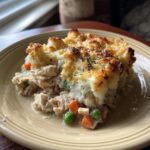 A slice of best shepherds pie recipe chicken on a plate, featuring chicken, vegetables, and a mashed potato topping.