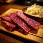 Close-up of sliced corn beef and cabbage recipe on a wooden board, showcasing the tender texture.