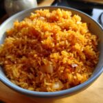 Close-up of a bowl of fluffy easy Mexican rice in a rice cooker, showing the vibrant color and texture.